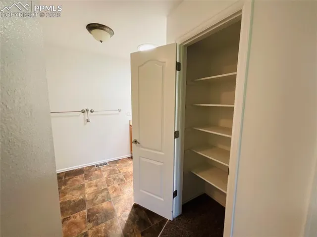 a view of walk in closet with empty racks