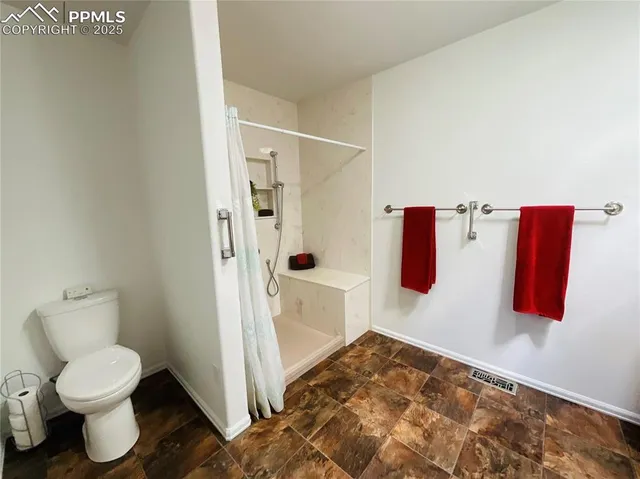 a bathroom with a toilet and a shower