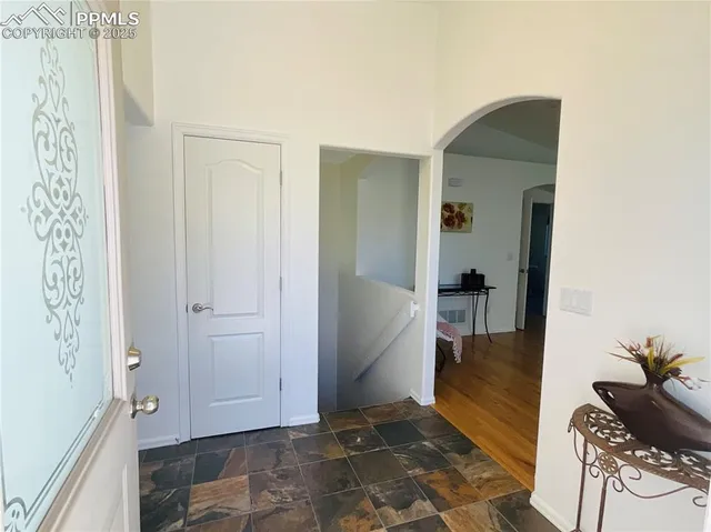 a view of a hallway with wooden floor and a living room