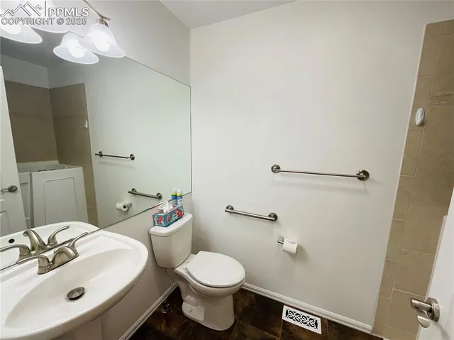 a bathroom with a sink a toilet and mirror