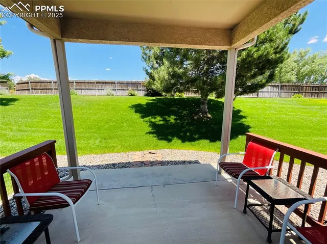 a view of an chairs and table in patio with a yard