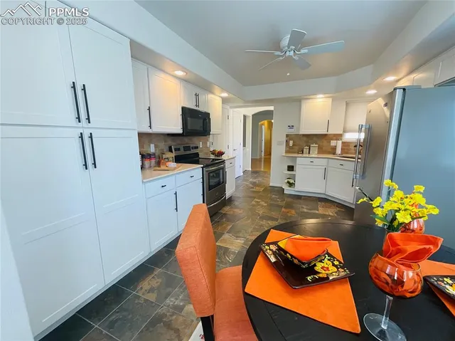 a kitchen with stainless steel appliances kitchen island granite countertop a refrigerator a stove a sink dishwasher and a microwave with wooden floor