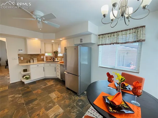 a kitchen with stainless steel appliances granite countertop a sink dishwasher and a refrigerator with wooden floor