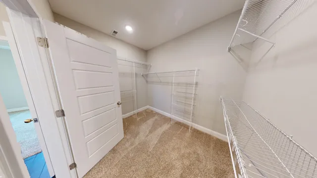 a view of walk in closet with empty racks