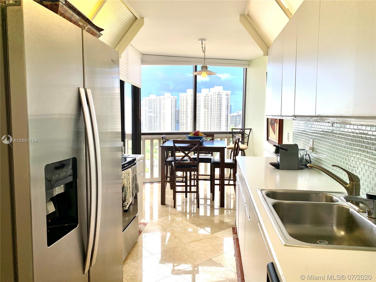 Williams Island Aventura, FL 33160 - Photo 11 of 23 a kitchen with stainless steel appliances granite countertop a sink refrigerator and cabinets