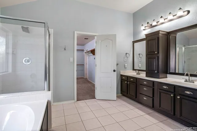 a spacious bathroom with a tub sink shower and mirror