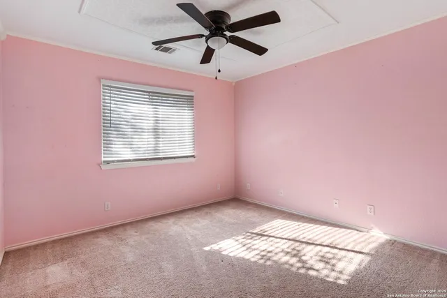 a view of a big room with windows and chandelier fan