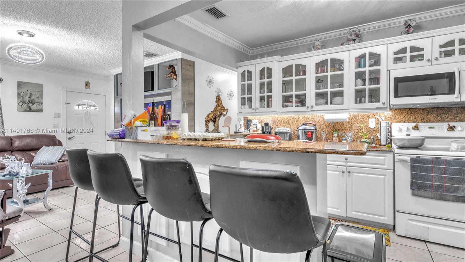 770 Southeast 4th Place Hialeah, FL 33010 - Photo 1 of 19 a kitchen with stainless steel appliances a dining table and chairs in it