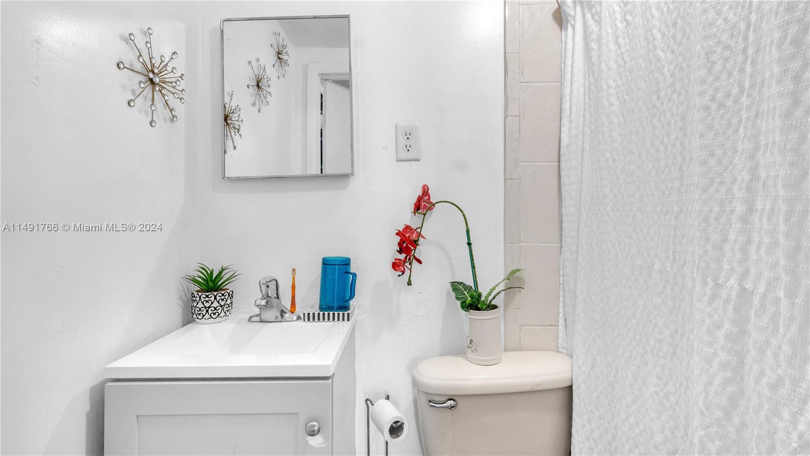 770 Southeast 4th Place Hialeah, FL 33010 - Photo 14 of 19 a bathroom with a sink a toilet and a mirror