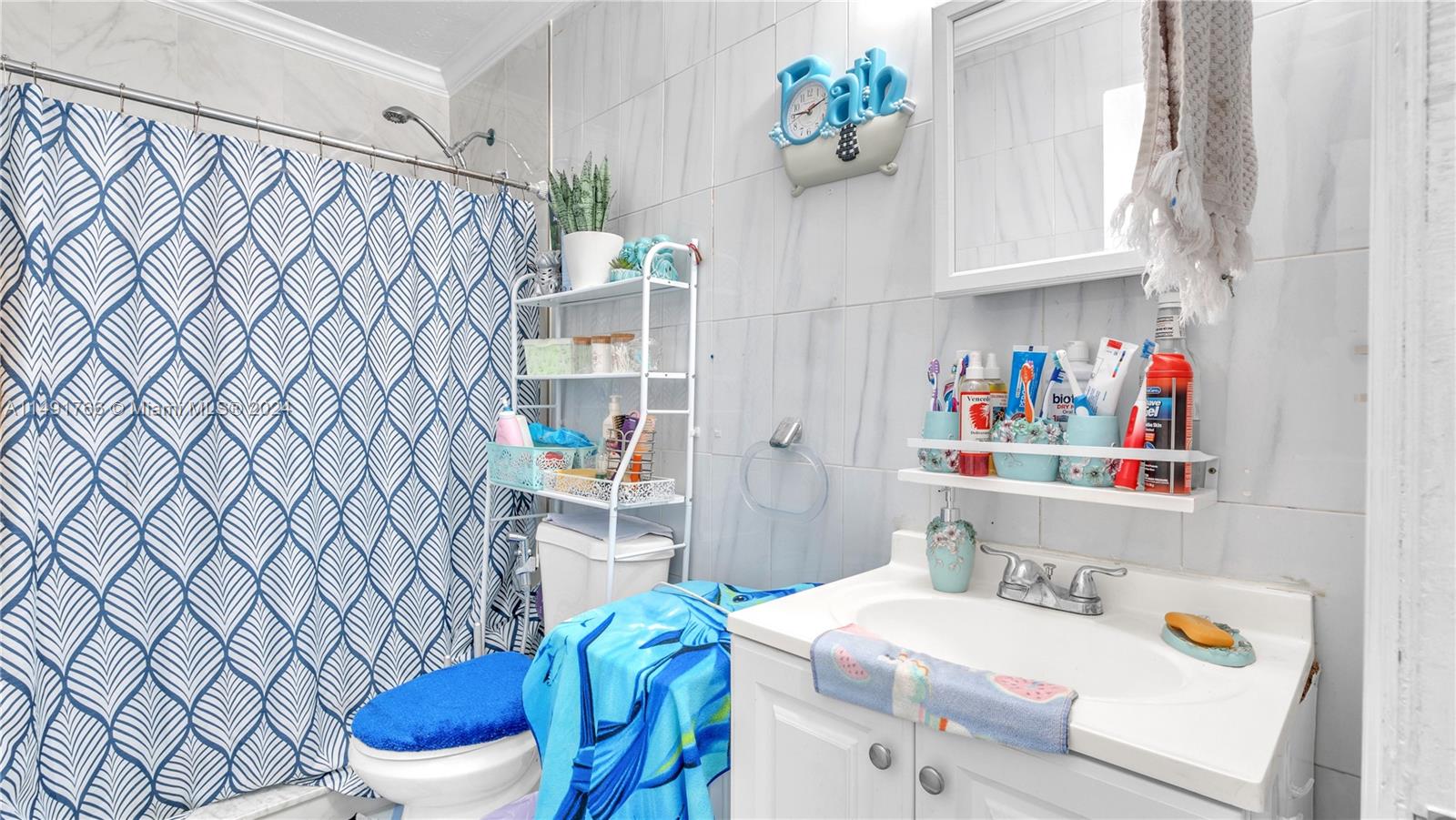 770 Southeast 4th Place Hialeah, FL 33010 - Photo 16 of 19 a bathroom with a sink a toilet and a shower curtain