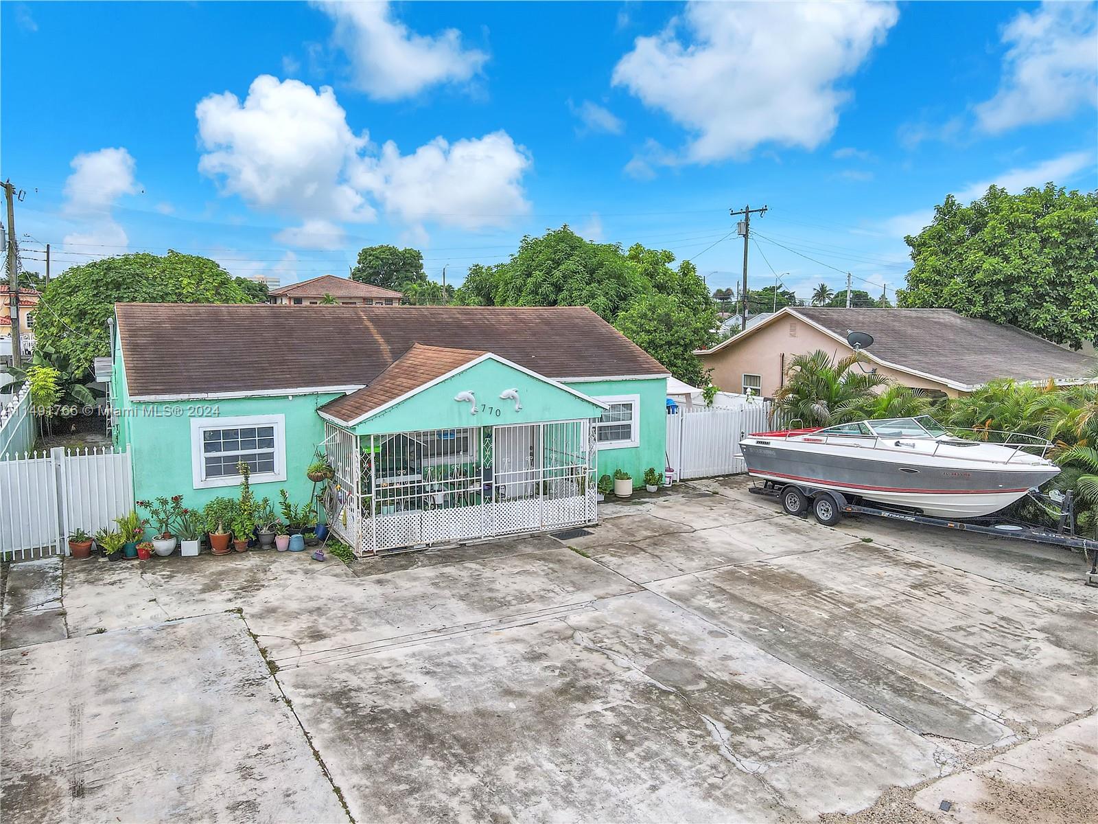 770 Southeast 4th Place Hialeah, FL 33010 - Photo 2 of 19 a view of a house with a yard and potted plants