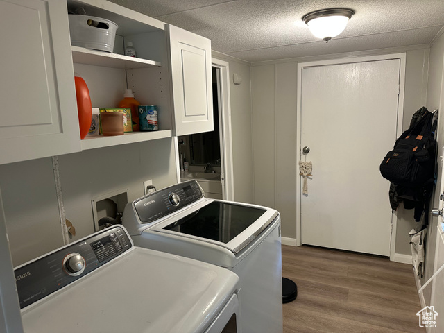 1375 West 500th North, Unit 95 Provo, UT 84601 - Photo 6 of 19 Washroom featuring dark wood-style flooring, cabinet space, a textured ceiling, and independent washer and dryer