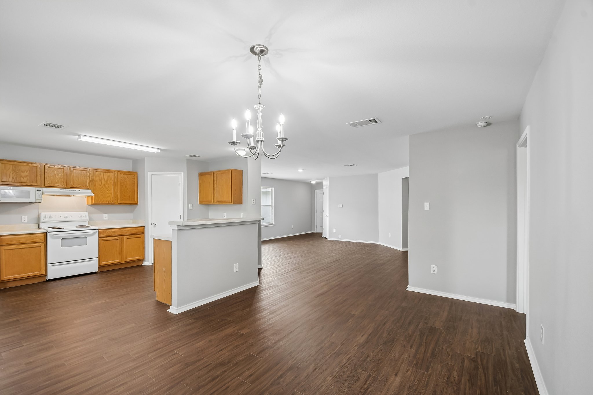 610 Lavaca Loop Elgin, TX 78621 - Photo 12 of 37 An open-concept layout unites kitchen and living spaces, featuring resilient laminate flooring.