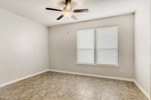 an empty room with a window and a fan