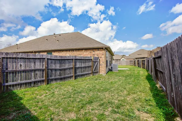 a view of a backyard with wooden fence