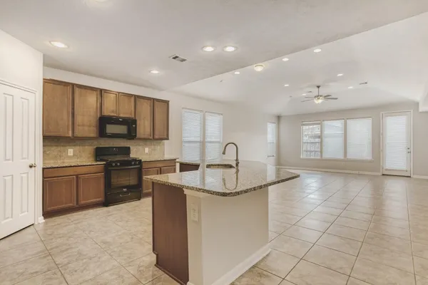 a large kitchen with stainless steel appliances granite countertop a large counter top and a stove top oven