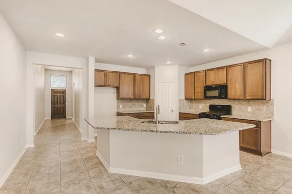 a kitchen with stainless steel appliances granite countertop a sink and a refrigerator