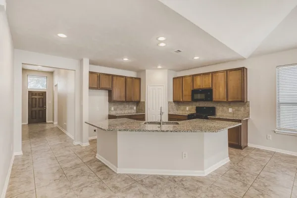 a large kitchen with stainless steel appliances granite countertop a large counter top and a stove top oven