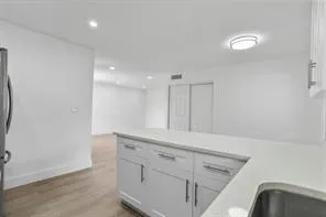 a view of a storage and utility room with wooden floor