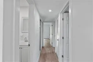 a view of a hallway with wooden floor and closet area