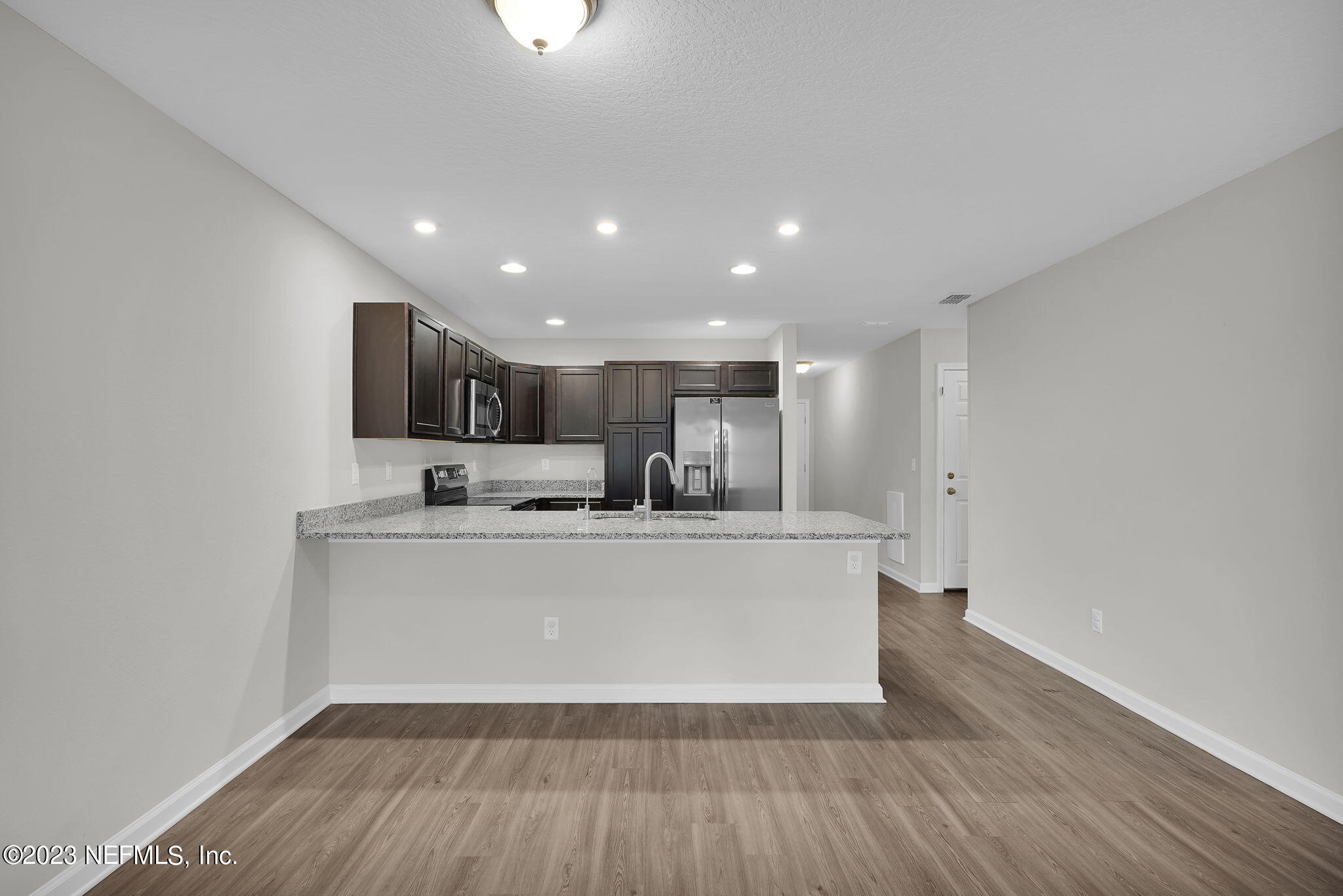 3082 Jennings Road Jacksonville, FL 32218 - Photo 5 of 17 a living room with stainless steel appliances a kitchen island a sink a stove a microwave and cabinets