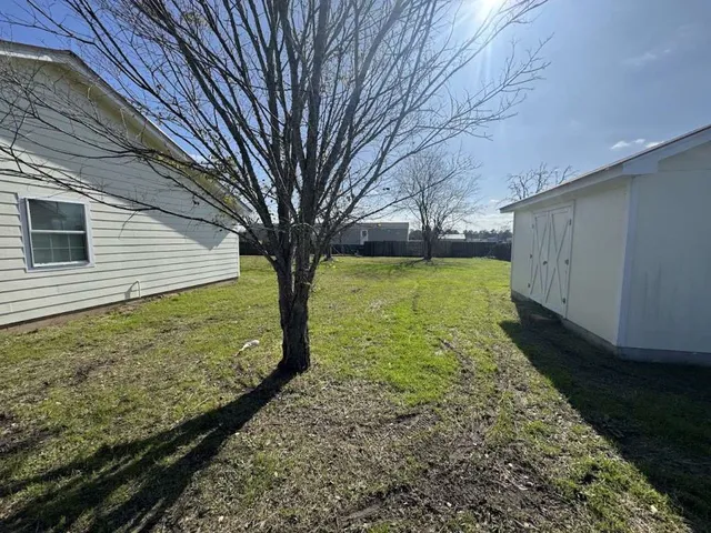 a view of a backyard with large trees