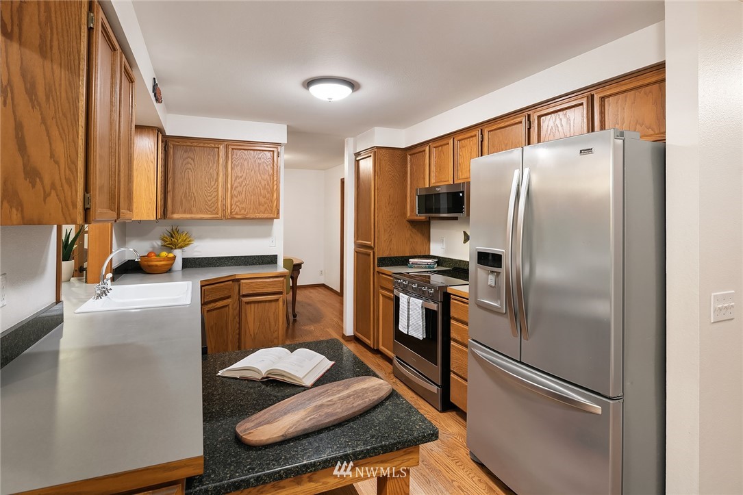 21031 Shell Valley Way Edmonds, WA 98026 - Photo 10 of 32 a kitchen with stainless steel appliances granite countertop a refrigerator sink and stove