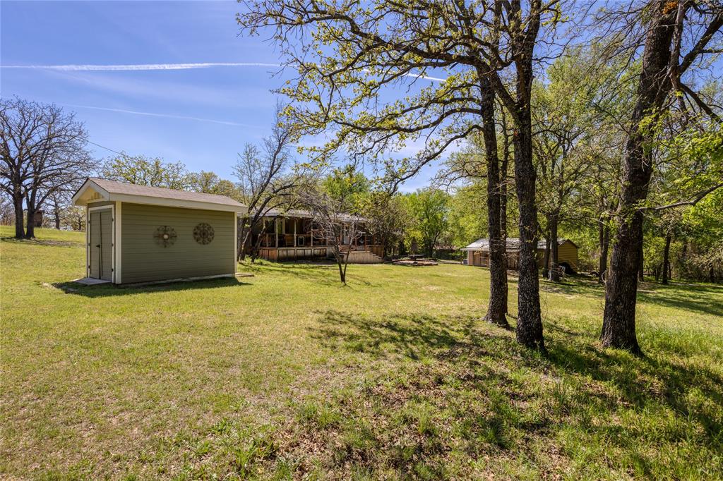 1701 Central Road Weatherford, TX 76088 - Photo 37 of 40 View of grassy yard featuring a storage unit/shed.