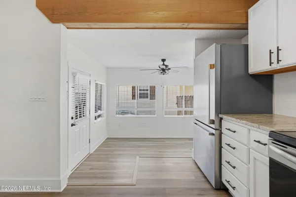 a view of empty room with wooden floor and fan