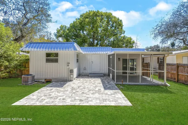 an aerial view of residential houses with outdoor space and trees