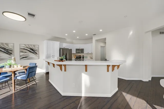 a kitchen with stainless steel appliances granite countertop a white cabinets and wooden floor