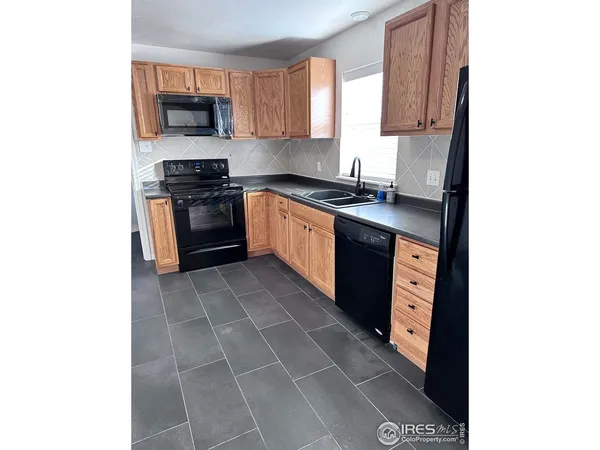 a kitchen with stainless steel appliances a sink a stove top oven a microwave a counter top space and cabinets