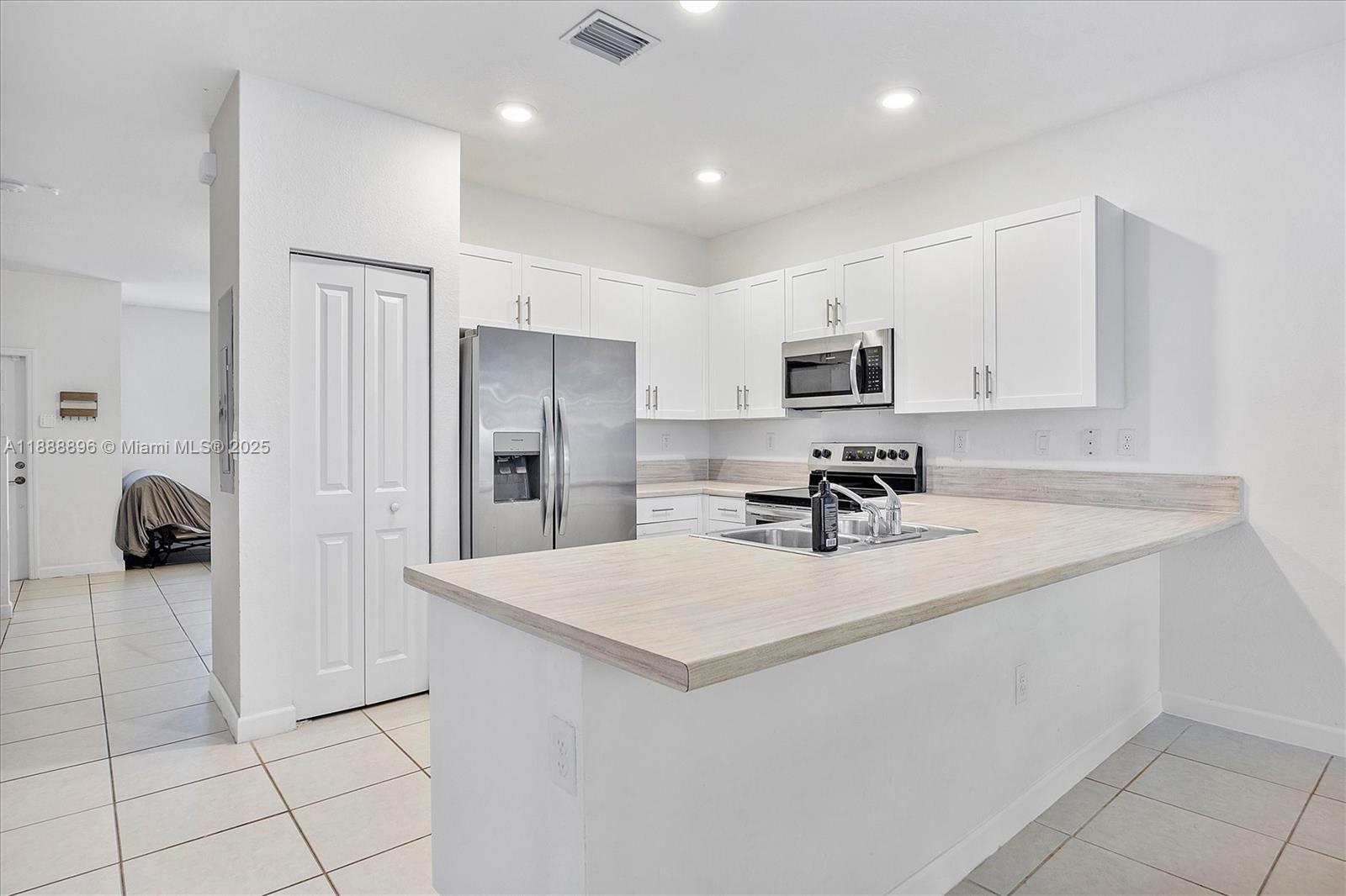 10013 Southwest 228th Terrace, Unit 10013 Miami, FL 33190 - Photo 14 of 39 a kitchen with a refrigerator and a sink