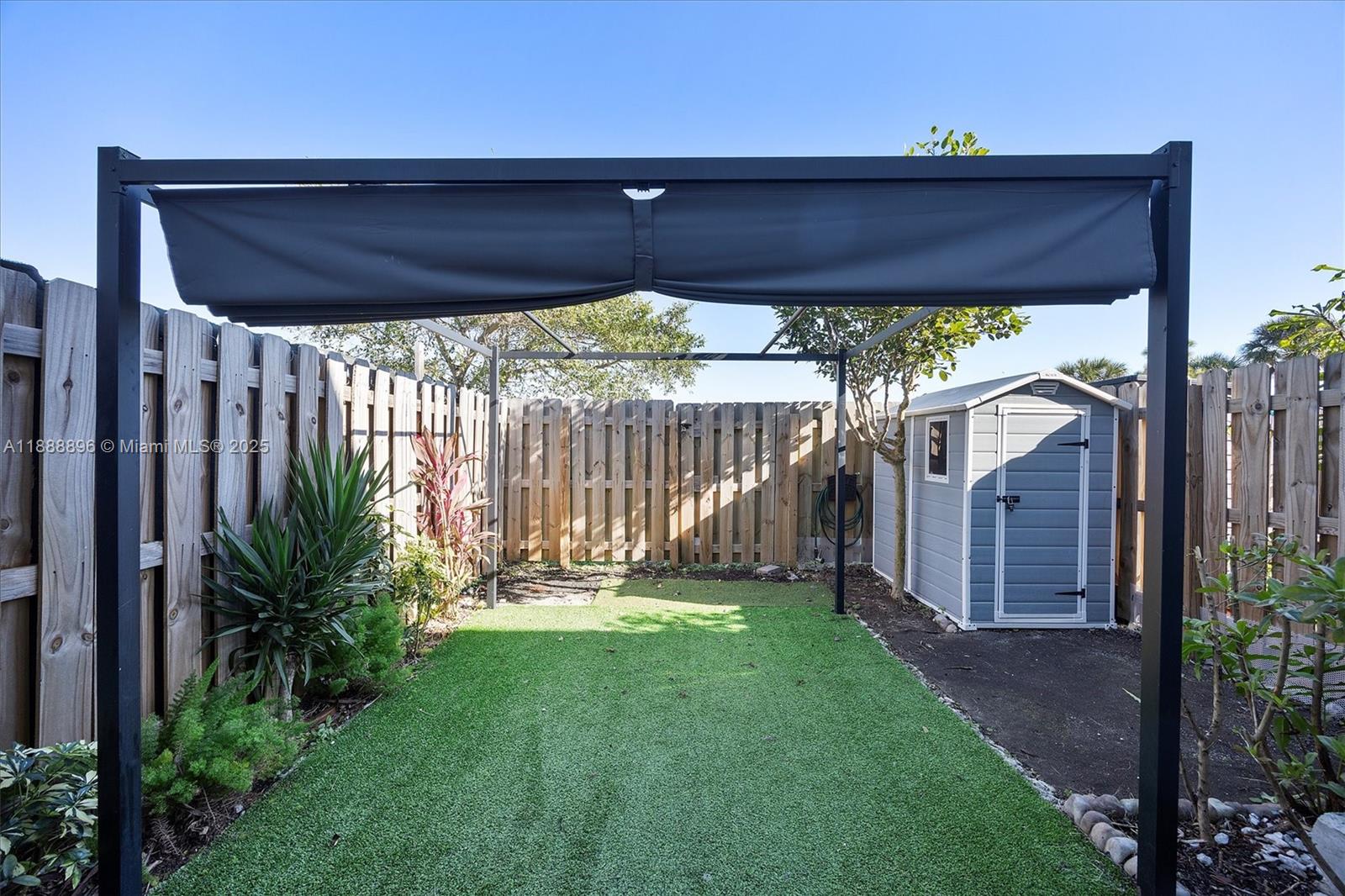 10013 Southwest 228th Terrace, Unit 10013 Miami, FL 33190 - Photo 38 of 39 a view of a porch with a floor to ceiling window and a yard