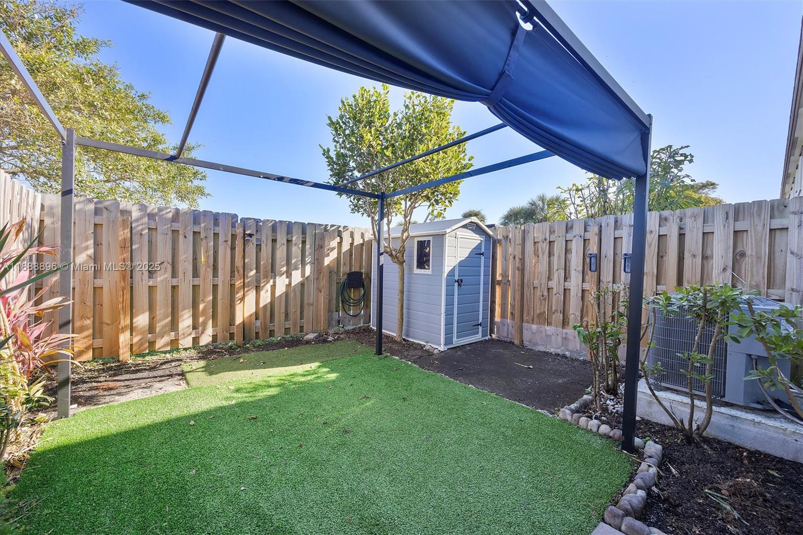 10013 Southwest 228th Terrace, Unit 10013 Miami, FL 33190 - Photo 39 of 39 a view of a backyard with wooden fence