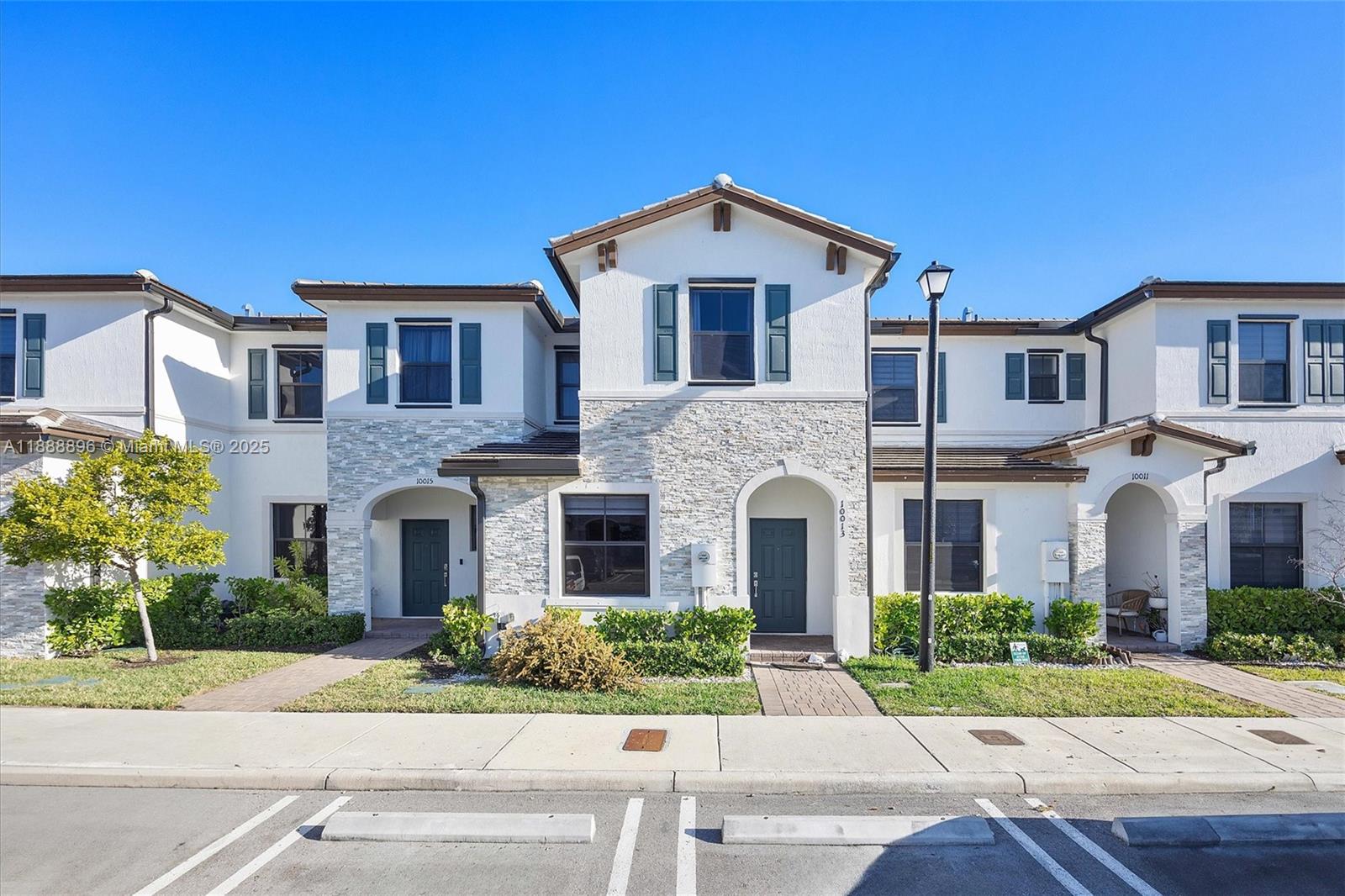 10013 Southwest 228th Terrace, Unit 10013 Miami, FL 33190 - Photo 4 of 39 a front view of a house with a yard