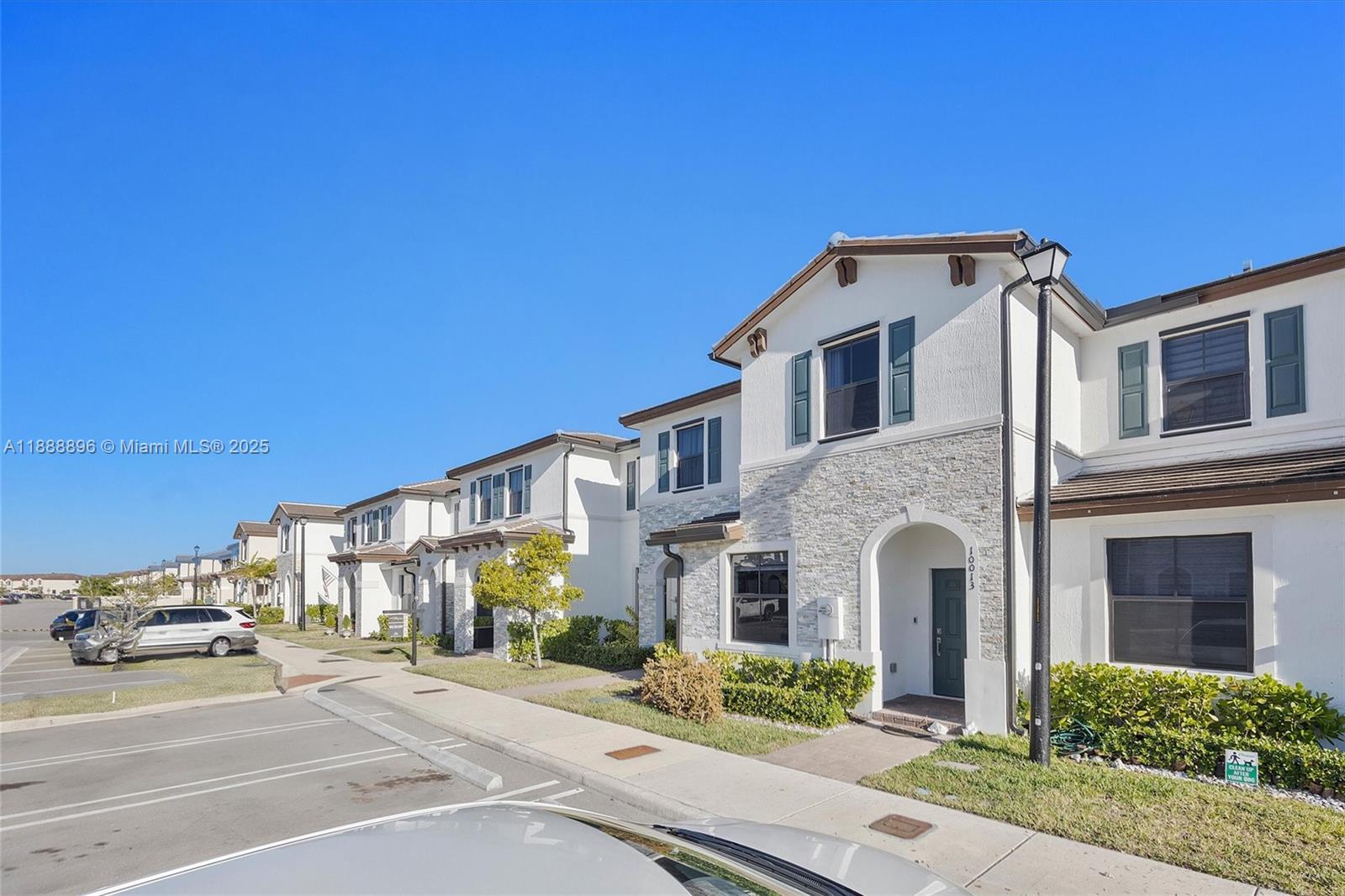 10013 Southwest 228th Terrace, Unit 10013 Miami, FL 33190 - Photo 5 of 39 a front view of a house with a yard