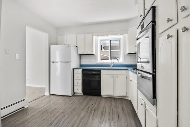 a kitchen with a refrigerator sink and cabinets