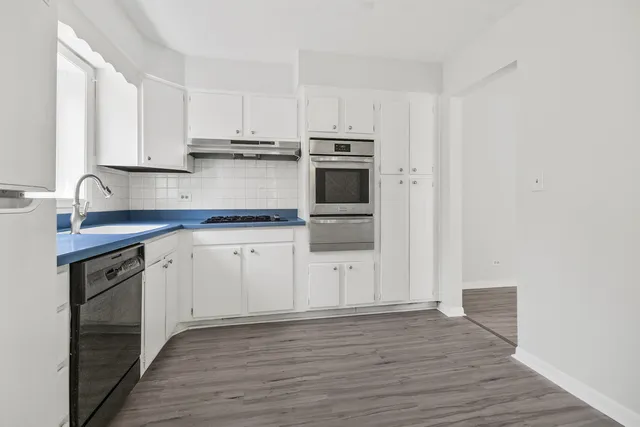 a kitchen with white cabinets stainless steel appliances and sink