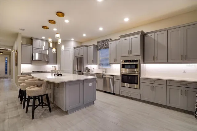 a spacious bedroom with a bed and dresser with mirror