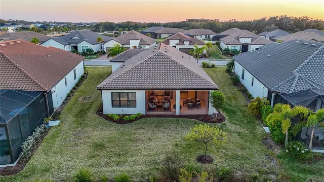 an aerial view of residential houses with outdoor space and swimming pool