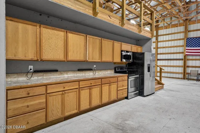 a kitchen with granite countertop a stove a sink and a refrigerator