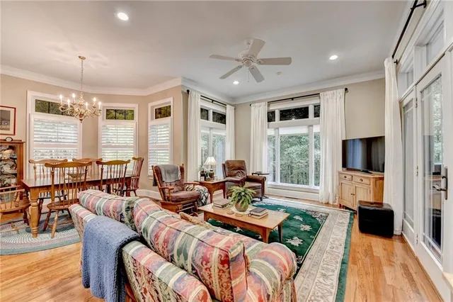a living room with furniture kitchen view and a large window