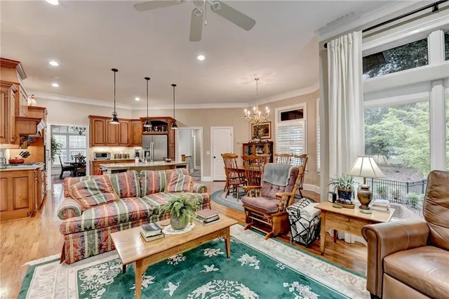 a living room with furniture a flat screen tv and a large window