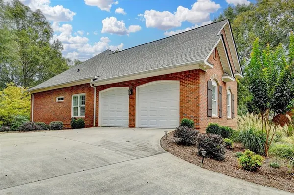 a front view of house with yard and trees in the background