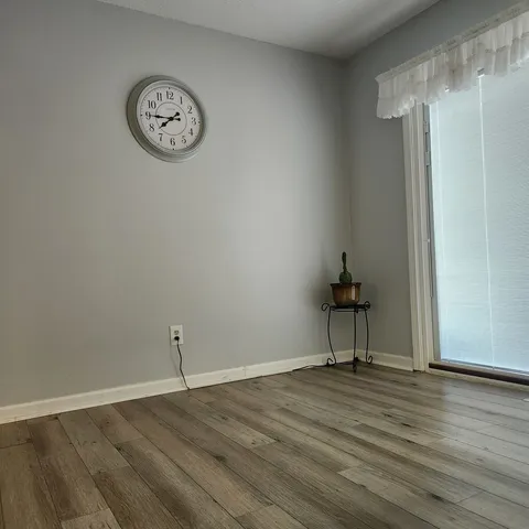 a view of a room with wooden floor and a window