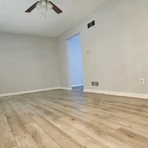 a view of an empty room with wooden floor