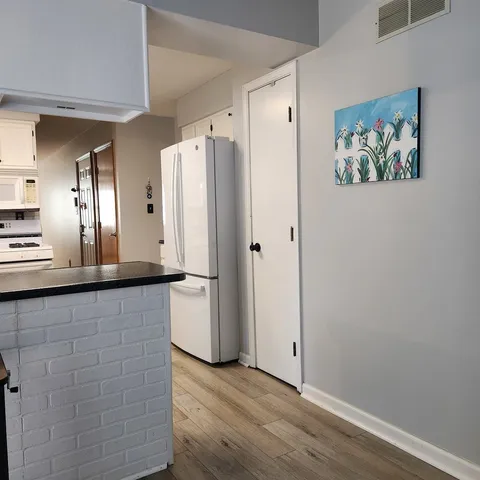 a view of a refrigerator in kitchen and wooden floor
