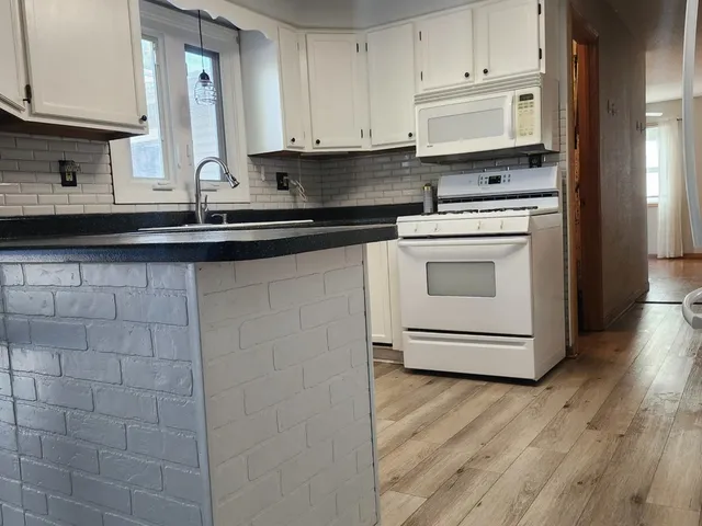 a kitchen with stainless steel appliances granite countertop a sink a stove and cabinets