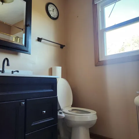 a bathroom with a toilet a sink and a window